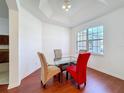 Dining area with modern glass table, colorful chairs, and bright window at 603 Deauville Ct, Kissimmee, FL 34758