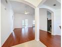 Spacious living room with hardwood floors, ceiling fan and archway entry to kitchen and french doors at 603 Deauville Ct, Kissimmee, FL 34758