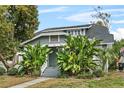 Inviting home featuring a cozy front porch and lush tropical foliage at 627 N Hyer Ave, Orlando, FL 32803