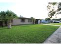 A well-kept single-story home with a lush green lawn and mature palm trees, exuding curb appeal at 7119 Leighton Way, Orlando, FL 32822