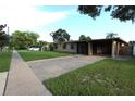 Single-story home with a covered carport and a brick-paved driveway leading up to the front entrance at 7119 Leighton Way, Orlando, FL 32822