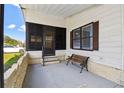 Cozy front porch with a bench, screen door, and brick accents offer a welcoming outdoor space at 721 Polo Park Blvd, Davenport, FL 33897