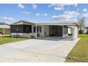 Charming home featuring a long drive and carport, screened porch, and well-maintained landscaping at 721 Polo Park Blvd, Davenport, FL 33897