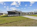 Inviting single-story home with a screened porch and covered carport, enhanced by a neatly manicured lawn at 721 Polo Park Blvd, Davenport, FL 33897