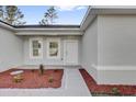 Inviting front entrance with tasteful landscaping and a modern, neutral-colored exterior at 773 Marion Oaks Pass, Ocala, FL 34473