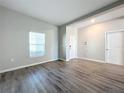 Living room with gray-toned wood floors, a large window for natural light, and neutral paint at 917 Carmillion Ct, Groveland, FL 34736