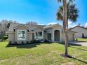 Charming home featuring a well-manicured lawn and stucco facade and well-lit by large windows at 10012 Silver Bluff Dr, Leesburg, FL 34788
