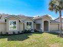 Charming home featuring a well-manicured lawn and stucco facade and well-lit by large windows at 10012 Silver Bluff Dr, Leesburg, FL 34788
