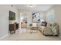 Bright living room with tile floors, comfortable seating, modern decor, and an open view to the bedroom at 103 Ford Ave, Altamonte Springs, FL 32701