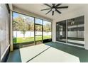 Relaxing screened-in patio with ceiling fan and views of the backyard and white vinyl fence at 1598 Barberry Dr, Kissimmee, FL 34744