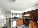 Open kitchen with dark cabinets, stainless steel appliances, and view to living room at 1866 Caralee Blvd # 3, Orlando, FL 32822