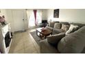 Cozy living room featuring a fireplace, neutral tile floors, and a comfortable gray couch at 1866 Caralee Blvd # 3, Orlando, FL 32822