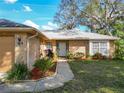 Charming brick home with a cozy walkway leading to the entrance, surrounded by lush landscaping at 2031 Roseway Ave, Deltona, FL 32738