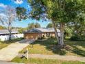 Inviting single-Gathering home with brick facade, mature trees, a well-kept lawn, and a two-car garage at 2031 Roseway Ave, Deltona, FL 32738