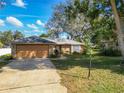 Beautiful single-story home with well-maintained lawn and landscaping, featuring brick facade and mature trees at 2031 Roseway Ave, Deltona, FL 32738