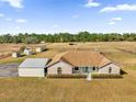 An aerial view of a one-story home with brick accents and a huge front and side yard at 36525 Reserve Dr, Eustis, FL 32736