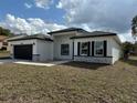 Newly built home with a black roof, crisp white facade, and minimalist landscaping at 4650 Sw 139Th Pl, Ocala, FL 34473