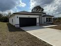 A contemporary-style house showcasing a dark garage door and complementary stonework accents at 4650 Sw 139Th Pl, Ocala, FL 34473