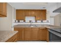 Kitchen with wood cabinets, stone countertops, neutral backsplash and stainless steel appliances at 6209 Beaumont Ave, Orlando, FL 32808