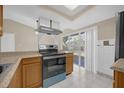 Eat-in kitchen featuring wood cabinets, stone countertops, and stainless steel appliances at 6209 Beaumont Ave, Orlando, FL 32808