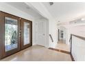 Bright foyer featuring marble flooring, glass paneled double doors, and white trim accents at 6766 Edgeworth Dr, Orlando, FL 32819