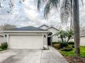 Charming single-story home with a well-maintained lawn, swaying palms and an attached two-car garage at 8233 Westcott Shore Dr, Orlando, FL 32829