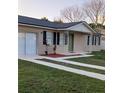 Charming single-story home featuring neutral paint, black shutters, and a well-maintained lawn at 106 Dahlia Dr, Kissimmee, FL 34743