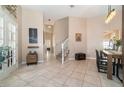 Inviting foyer boasts tile floors, neutral walls, staircase, and decorative accents leading to open living spaces and the dining room at 1428 Oberlin Ter, Lake Mary, FL 32746