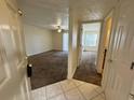 Bright, carpeted living room with fan and sliding glass door to let in natural light at 1940 Lake Atriums Cir # 108, Orlando, FL 32839