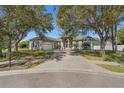 Traditional home with large trees shading the front lawn and driveway leading to a two-car garage at 1946 Thoroughbred Dr, Gotha, FL 34734