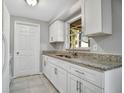 Bright kitchen featuring white cabinets, granite countertops, and stainless steel sink at 210 Cadillac Ct, Altamonte Springs, FL 32701