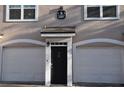 Close up exterior showcasing the front door nestled between two white garage doors at 3307 Greenwich Village Blvd # 205, Orlando, FL 32835