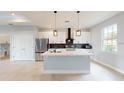 Modern kitchen featuring an island with a sink and a stainless steel refrigerator at 400 Miami Way, Poinciana, FL 34759