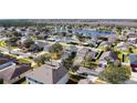 Picturesque aerial view of a neighborhood featuring mature trees and a tranquil lake at 4012 Longworth Loop, Kissimmee, FL 34744