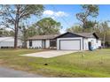 Exterior view of a single-story home featuring a freshly painted exterior, two-car garage, and well-maintained landscaping at 4870 Oriole Dr, St Cloud, FL 34772