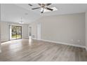 Spacious living room features wood-look flooring, a high ceiling with fan, and sliding glass doors to the outside at 4870 Oriole Dr, St Cloud, FL 34772