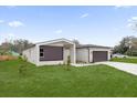 Modern home showcasing a well-manicured lawn, concrete driveway, and a two-car garage at 501 Dean Creek Ln, Orlando, FL 32825