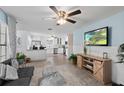 Bright open-concept living room featuring a modern kitchen and a comfortable seating area with a large-screen TV at 516 8Th St, Orlando, FL 32820