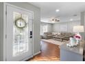 Inviting foyer with a decorative glass door and hardwood floors, leading into a cozy living room at 52 Bay Ridge Loop, Mascotte, FL 34753