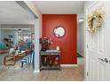 Warm and inviting foyer with neutral tile flooring, red accent wall, and decorative touches at 5359 Lanyard Ct, Winter Park, FL 32792