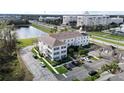 Aerial view of the condo, showing convenient parking, beautiful landscaping, and pond view at 770 Siena Palm Dr # 201, Kissimmee, FL 34747