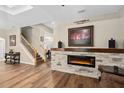 Living room featuring a fireplace, wooden floors, and a staircase at 932 Classic View Dr, Auburndale, FL 33823