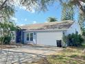 Light blue single-story home featuring a two-car garage and mature landscaping in the front yard at 146 Brad Cir, Winter Haven, FL 33880