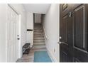 Inviting entryway with a staircase, light wood floors and a black front door at 167 Villa Di Este Ter Ter # 213, Lake Mary, FL 32746