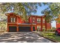 Spacious two-story red home with a garage and well-kept landscaping at 167 Villa Di Este Ter Ter # 213, Lake Mary, FL 32746