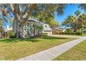 Beautiful exterior view of a home with a lush green lawn, mature trees, and a sidewalk at 1709 Palm Beach Dr, Apopka, FL 32712