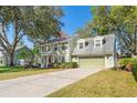 Two story home with a green lawn, a two-car garage, manicured hedges, and mature trees at 1709 Palm Beach Dr, Apopka, FL 32712