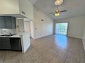 Open-concept living space with tile flooring, kitchen, and natural light from a sliding glass door at 1932 Lake Atriums Cir # 85, Orlando, FL 32839