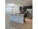 Open kitchen with island, stainless steel appliances, granite countertops and tiled floors at 2355 Seven Oaks Dr, St Cloud, FL 34772
