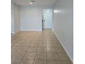 Spacious living room with tile flooring and neutral walls, leading to the entryway door at 2355 Seven Oaks Dr, St Cloud, FL 34772